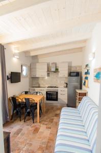 a living room with a table and a kitchen at Dimora Mare in San Teodoro
