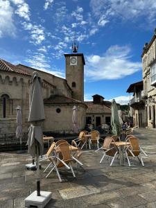 a group of chairs and umbrellas in front of a building at Casa Anita - Ribeira Sacra in Os Peares