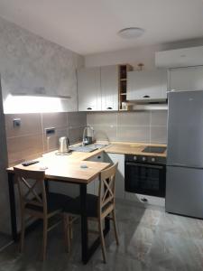 a kitchen with a wooden table and a refrigerator at Nemanjina Centar in Pančevo