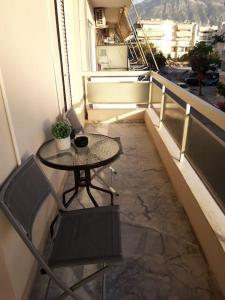 d'une petite table et d'une chaise sur un balcon. dans l'établissement Comfort apartment in the city, à Kalamata