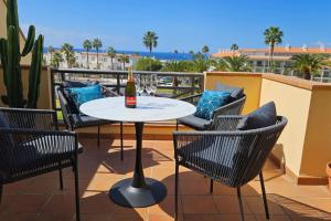 a table and chairs on a balcony with a bottle of wine at Sea view el veril in Adeje