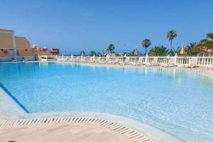 a large swimming pool with chairs in a resort at Sea view el veril in Adeje