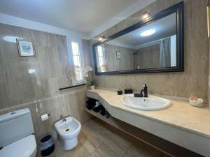 a bathroom with a sink and a toilet and a mirror at Sea view el veril in Adeje