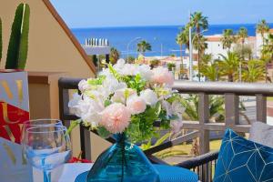 a blue vase filled with pink and white flowers on a table at Sea view el veril in Adeje