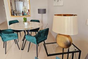 a dining room with a table and chairs and a lamp at Sea view el veril in Adeje