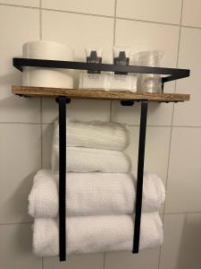einen Haufen Handtücher auf einem Regal im Bad in der Unterkunft Terråk Gjestegård in Terråk