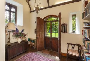 een kamer met een deur en een tafel en stoelen bij Chapel Knap Porlock Weir in Porlock