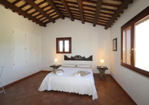 1 dormitorio con 1 cama blanca en una habitación con ventanas en Villa Colli Ericini, en Baglio Rizzo