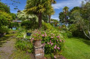 een tuin met bloemen en een palmboom bij Chapel Knap Porlock Weir in Porlock