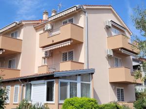 an apartment building with balconies and trees at Rooms Magdalena Krk in Krk
