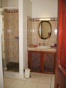 a bathroom with a sink and a shower with a mirror at Domaine des Sloughis in Meknès