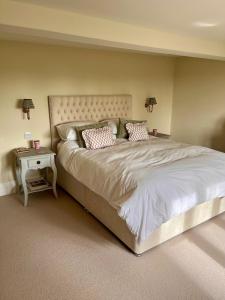 a bedroom with a large bed and a side table at Upper Stowe in Church Stowe