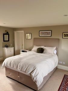 ein Schlafzimmer mit einem großen Bett mit einer weißen Bettdecke in der Unterkunft Upper Stowe in Church Stowe