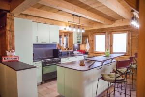 a kitchen with white cabinets and a stove top oven at Chalet La Trafolée in Manigod