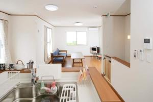a kitchen with a sink and a living room at iruka - Vacation STAY 19721v in Nago