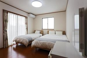 a bedroom with two beds and a window at iruka - Vacation STAY 19721v in Nago