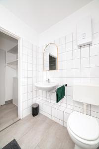 a white bathroom with a toilet and a sink at Perfect for 6 guests Kitchen Parking Netflix in Wuppertal