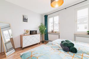 a bedroom with a bed and a mirror and windows at Perfect for 6 guests Kitchen Parking Netflix in Wuppertal
