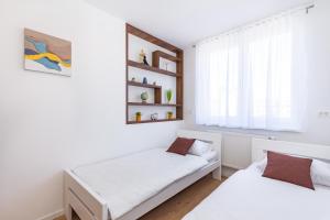 - une chambre avec 2 lits et une fenêtre dans l'établissement Apartman Krželj A3, à Livno