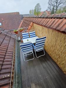 Duas cadeiras e uma mesa no terraço do último piso em Ferienwohnung Freise em Telgte