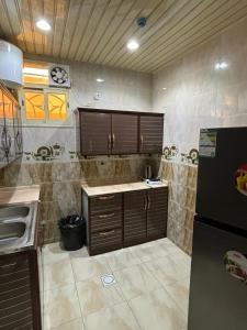 a kitchen with a sink and a refrigerator at قصر نوماس للشقق المخدومة الواديين in Al Wadeen