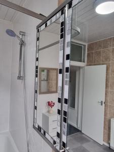 La salle de bains est pourvue d'une douche et d'un grand miroir. dans l'établissement Be our Guest! Stylish-Free parking-Central location, à Headingley