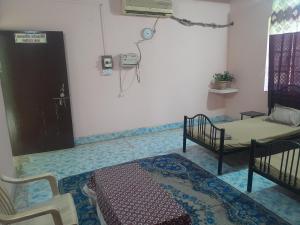 GovardhanにあるGiriraj Darshanのベッド2台、ソファ、電話が備わる客室です。