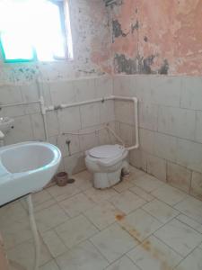 a bathroom with a toilet and a sink and a tub at Giriraj Darshan in Govardhan