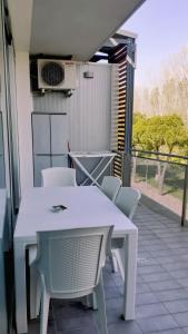 a white table and chairs on a balcony at Apartment Mare45 - 10 minutes walk from the beach - included parking, umbrella and sun-beds in Eraclea Mare