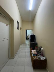 a room with a hallway with luggage and a table at Shan Studio Apartment in Hatta