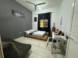 Zimmer mit einem Schreibtisch und einem Bett. in der Unterkunft Shan Studio Apartment in Hatta