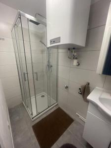 a bathroom with a shower with a glass door at Zentrales City Apartment in Graz