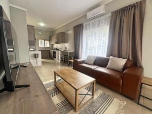 a living room with a brown couch and a table at Vaendzi Lodge in Nelspruit