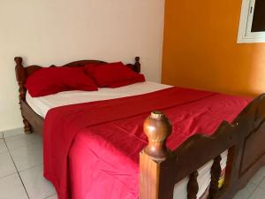 - une chambre avec un lit et une couverture rouge dans l'établissement chambre pour voyageur, à Bouéni
