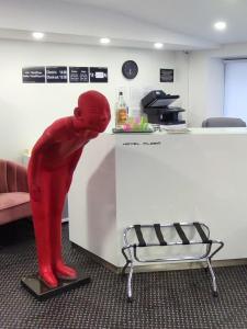 une statue rouge d'une personne se penchant sur un réfrigérateur dans l'établissement Hotel Plzeň, à Plzeň