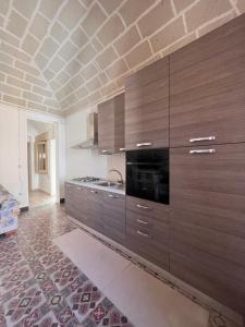 een keuken met bruine kasten en een bakstenen plafond bij Isola Serena in Favignana