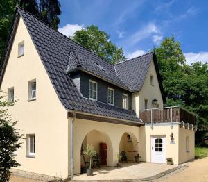 a large white house with a black roof at Feriensuite Tosca im Kuckuckswinkel in Schöna