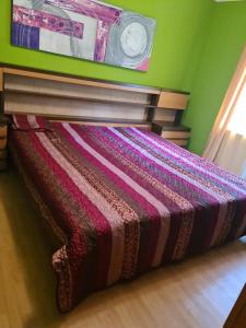 Cama en habitación con reloj en la pared en Garsoniera MAIA Slănic-Moldova, en Slănic-Moldova