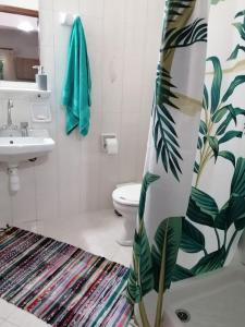 ein Badezimmer mit einem Duschvorhang, einem WC und einem Waschbecken in der Unterkunft Nikos Apartments 2 in Kavos
