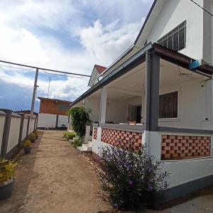 een wit huis met een pad ervoor bij Chez Jeanne Chambre d'Hôte in Antananarivo