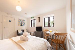 a bedroom with a bed and a table with chairs at Pass the Keys The White House Holiday Cottage in Highley