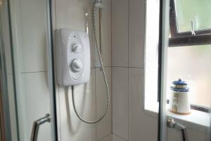 a shower in a bathroom with a shower at Pass the Keys The White House Holiday Cottage in Highley