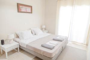 a white bedroom with a large bed and a window at Skyline Parorama in Mathía