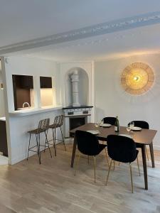 een eetkamer met een tafel en stoelen en een open haard bij Appartement d'architecte au cœur de Paris 9 in Parijs