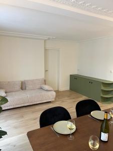 a living room with a couch and a table with wine glasses at Appartement d'architecte au cœur de Paris 9 in Paris