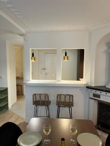 een woonkamer met een tafel en 2 stoelen bij Appartement d'architecte au cœur de Paris 9 in Parijs