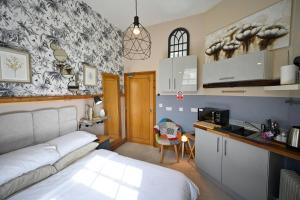 1 dormitorio pequeño con 1 cama y cocina en Cherry Tree Studio, en Telford