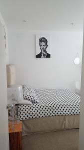 Una cama en una habitación con una foto de un hombre en Family home with easy commute to London! en Croydon