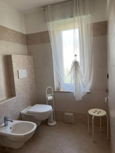 a bathroom with a toilet and a sink and a window at THE SUNFLOWER APARTMENT in Ronzo Chienis +17 photos