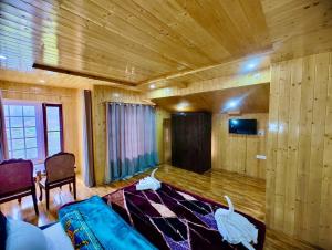 uma sala de estar com um sofá azul e uma televisão em Lady Pahalgam Resort Operated By Zaara Resorts em Pahalgam